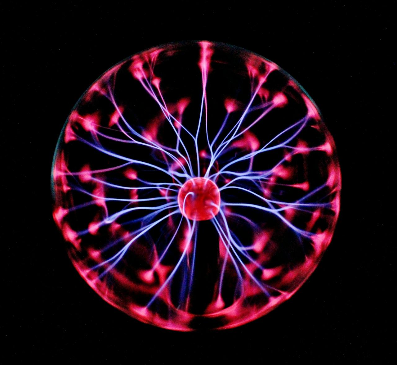 who-we-are Close-up of a plasma globe with vibrant neon sparks against a dark background.