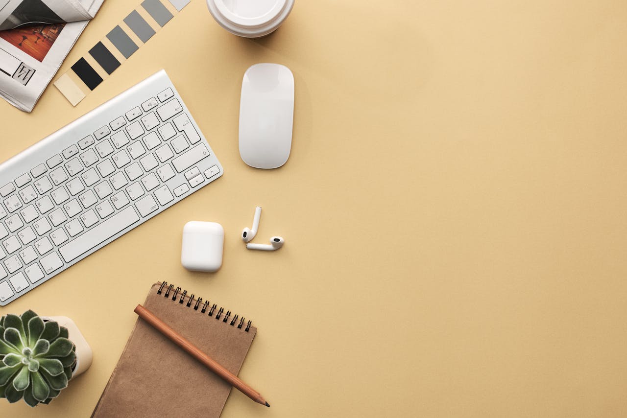 hero A minimalist workspace flat lay with keyboard, mouse, notebook, and succulent on a beige background.